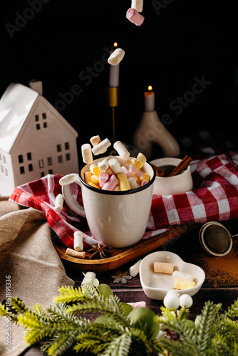 Cozy winter still life with cocoa, marshmallows and candle. Warm Christmas atmosphere and rustic home comfort concept.