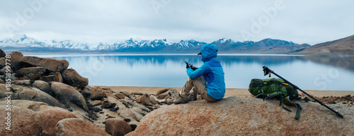 Bilde på lerret Backpacking woman taking photo with smartphone on high altitude mountain top