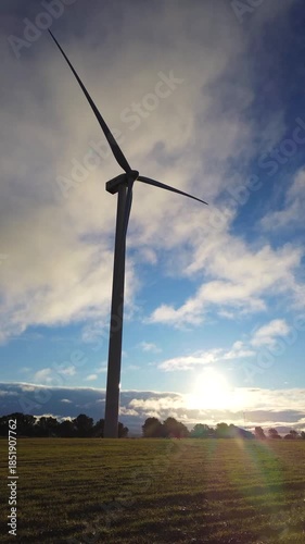 Wind Farm at Sunset, Turbines in Silhouette Against Cloudy Sky
