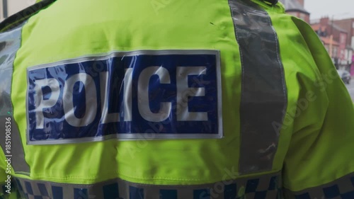 UK Police officer. CU high visibility uniform on police officer. City police.	
