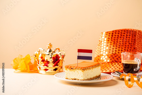 Stack of orange tompouce and donuts glazed donuts with red, white and blue sprinkles topped with a small Dutch flag on wooden board. National holiday Koningsdag on 27 April in the Netherlands