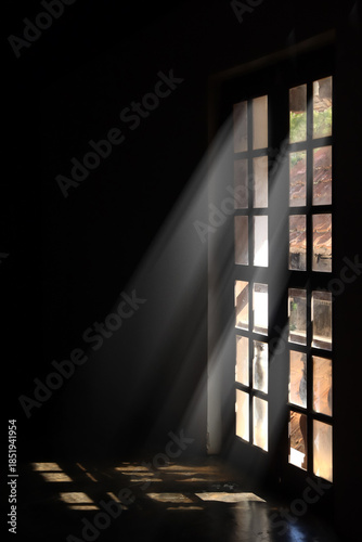 Fotografi Dramatic Sunlight Streaming Through Window Creating Light and Shadow Indoors