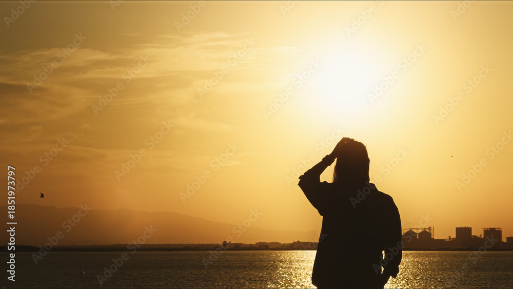 Obraz premium Lonely Figure Watching Sunset By The Sea at Sunset