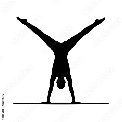 A silhouette captures a person performing a handstand with legs split wide apart