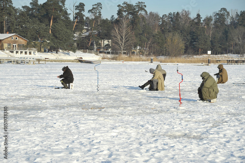 Ice fishing on the frozen Lielupe River, Jurmala, Latvia
