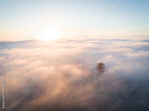 Golden sunset over Velka Homola, lookout tower rising from a sea of clouds. Little Carpathians, Slovakia