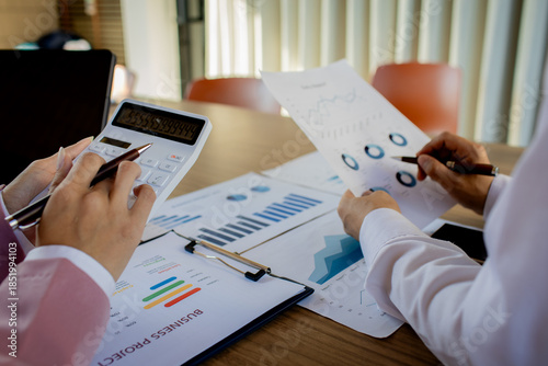 A professional female accountant sits at a desk, carefully examining legal paperwork and auditing financial records to finalize an important deal.