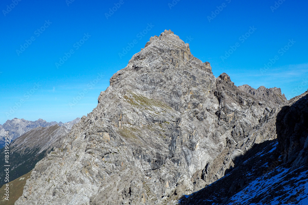 Obraz premium Wild Lechtal Alps with rugged peaks and a tranquil alpine mountain lake.