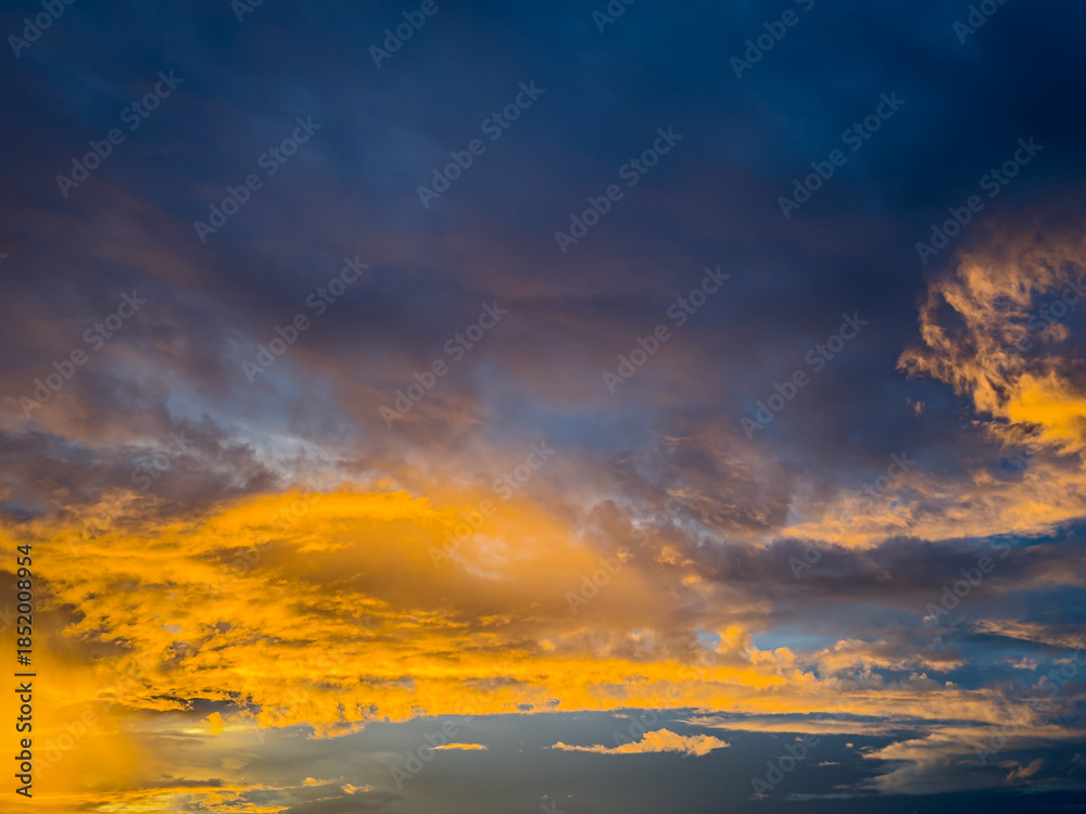Fototapeta premium Beautiful sky view at sunset or sunrise with orange clouds and blue sky background. Sky landscape at dusk.