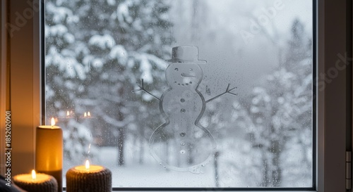 Snowman drawing on fogged window with snowy landscape outside  