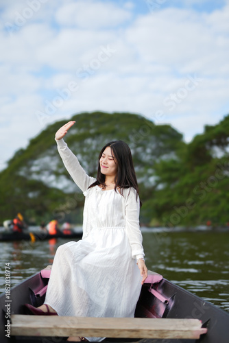 Close-up of a beautiful and lovely Asian woman taking a deep breath in a natural forest.