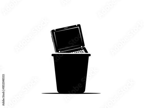 Laptop placed in trash bin symbolizing digital waste disposal  