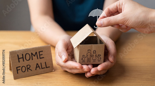Hands holding cardboard family house with umbrella icon over roof. Home insurance coverage, property protection, life safety and real estate security concept with Home for All text sign