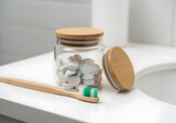 Glass jar with toothpaste tablets and bamboo toothbrush for zero waste oral care routine