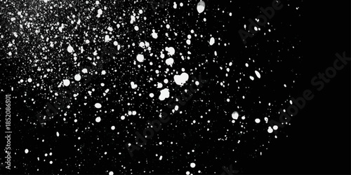 Snowstorm texture. Bokeh lights on black background, shot of flying snowflakes in the air.  Falling snow of different shapes and sizes.