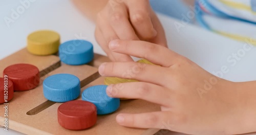 Child's Hands Playing with Colorful Wooden Puzzle Toy