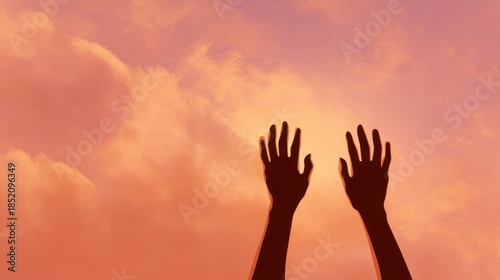 Two hands reaching upwards in silhouette against a vibrant sky with pink, orange, and blue clouds,