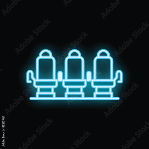 Glowing neon line icon of comfortable cinema seats illuminating the dark background