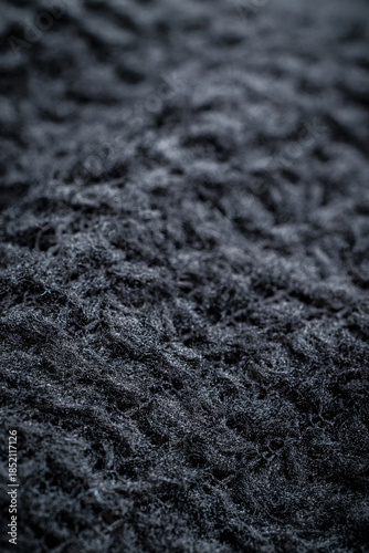 The fabric of black fleece, a synthetic knit with a soft, fluffy texture