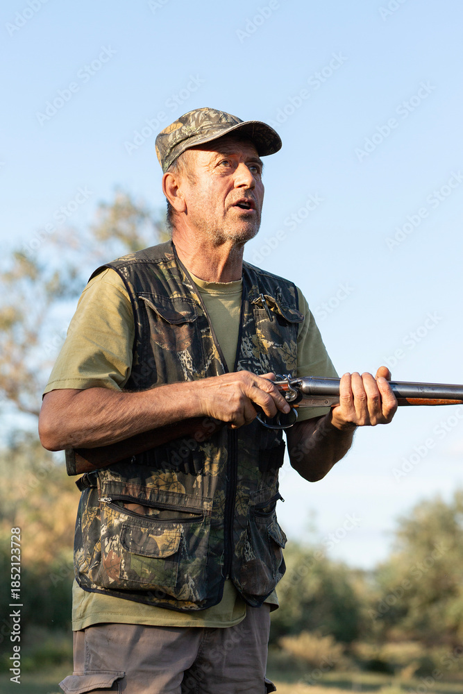 Fototapeta premium The hunter reloads his gun and prepares to shoot at game