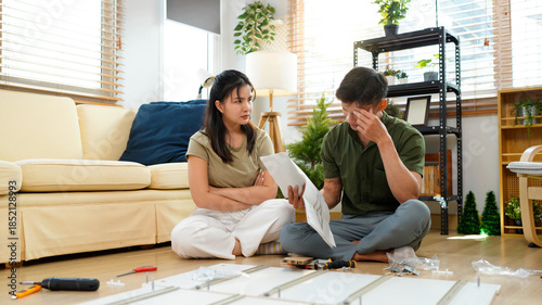 Frustrated couple having problems while assembling furniture in living room