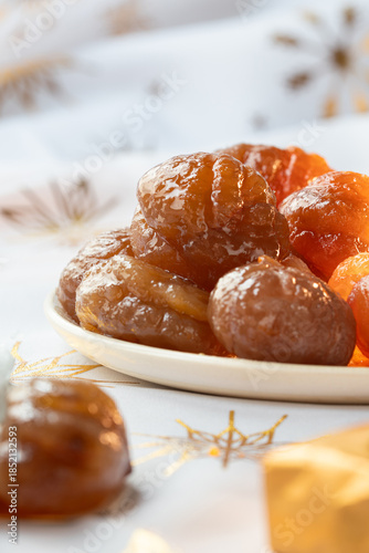 A plate of  French tradition candied chestnut or marron glacé with white background.