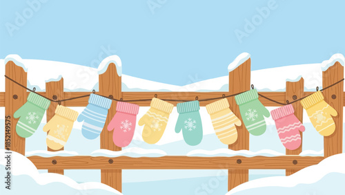 Colorful winter mittens hanging on a snowy fence outdoors