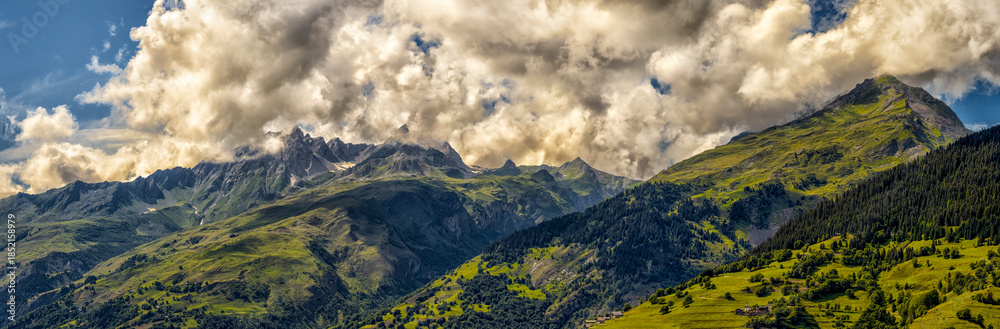 Obraz premium Summer mountain landscape with green peaks and cloudy sky