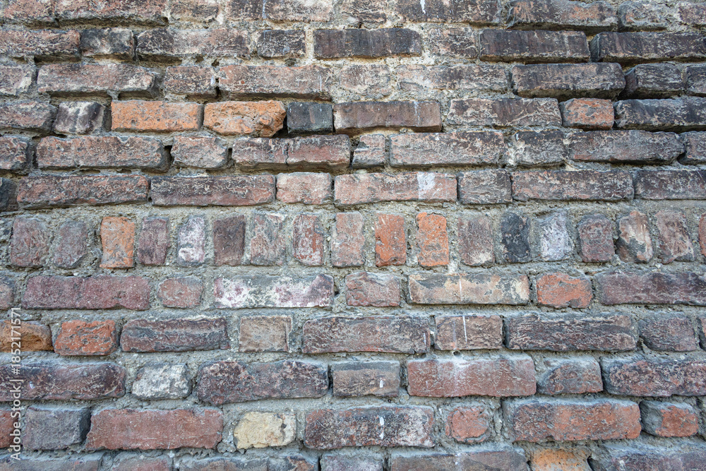 Fototapeta premium Weathered Brick Wall Texture With Rustic Earth Tones For Vintage Architecture Background
