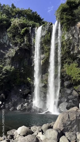 Beautiful view of the Jeongbang waterfall, one of the three main waterfalls of Jeju Island in South Korea, cascading into a serene pool