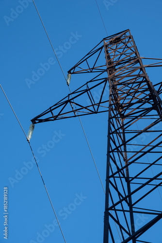 High-voltage power transmission tower against blue sky