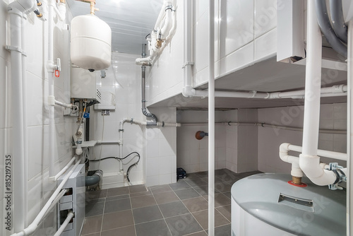 Photos A basement area features a water heater and multiple pipes arranged along the walls