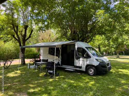 Camper van enjoying the shade of trees in a campsite in Azay le Rideau, France