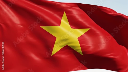 Flag of Vietnam with a single large yellow star on a red field, fluttering in the breeze against a clear sky.