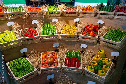 Buying vegetables at the market. Many kinds of vegetables on the local produce fruit and veg market. Includes runner beans, courgette, lemon, pepper, tomato, chilli, onion, carrot, lemon,  aubergine a