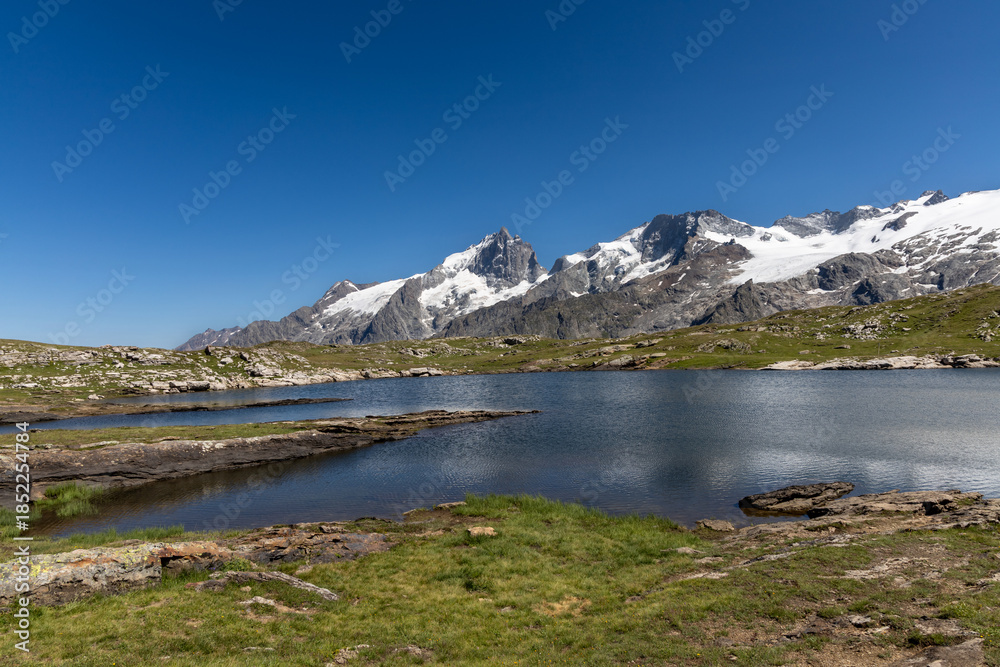 Naklejka premium Lac Noir with a scenic view of La Meije peak on the Emparis Plateau in the Arves Massif, Hautes-Alpes, France.