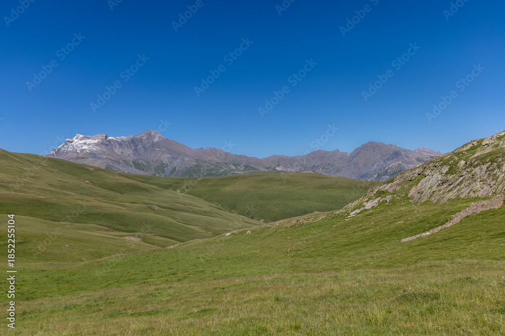 Fototapeta premium Mountain view of the Emparis Plateau in the Arves Massif, Hautes-Alpes, French Alps, featuring rugged peaks and alpine meadows.