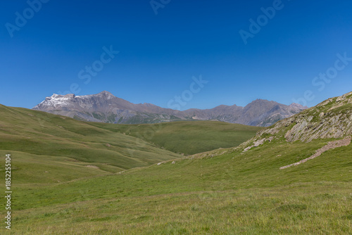 Mountain view of the Emparis Plateau in the Arves Massif, Hautes-Alpes, French Alps, featuring rugged peaks and alpine meadows.