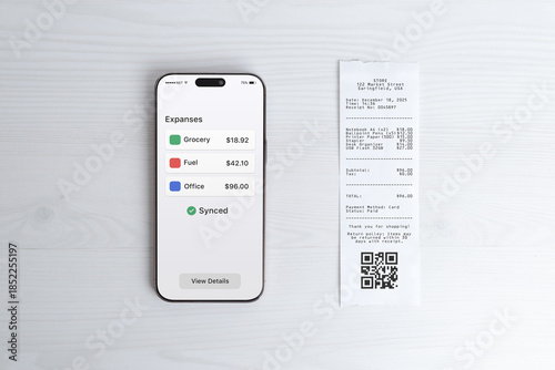 Photography Smartphone displaying expense overview dashboard next to paper receipt, modern b