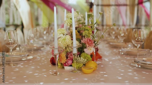Decorated dining table with floral centerpiece and elegant candles, wedding table setting perfect for any event