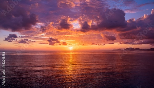 Majestic Sunset Over A Tranquil Ocean Featuring A Vibrant And Dramatic Cloudscape Painting The Sky With Brilliant Orange Yellow And Pink Hues A Serene Natural Landscape At Dusk