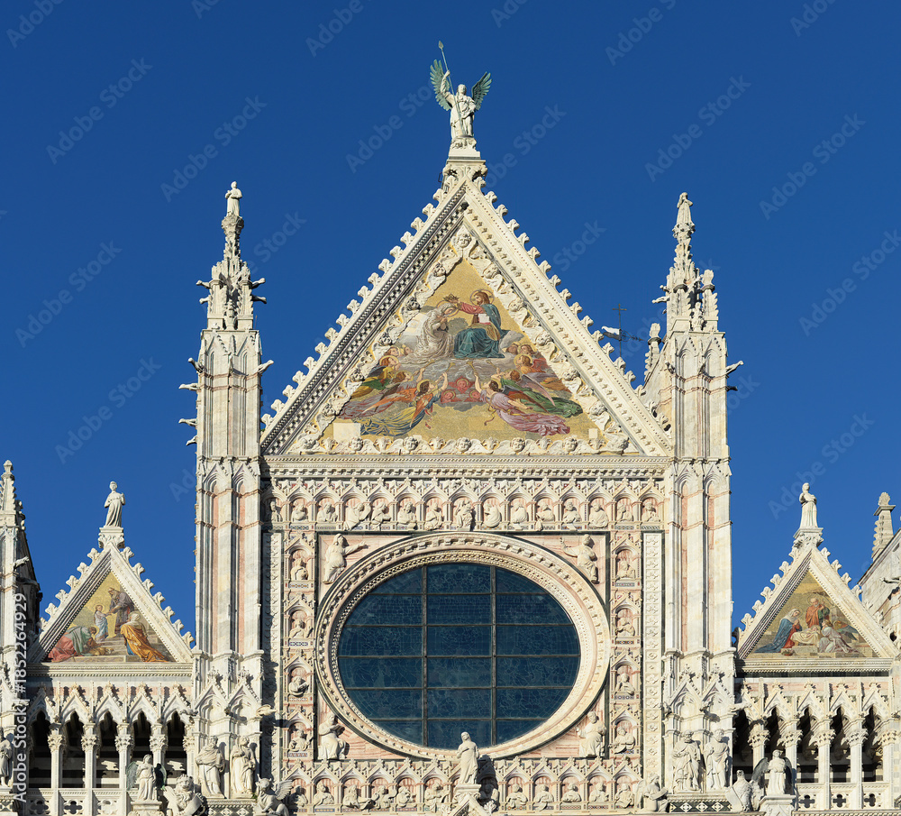 Naklejka premium Front top gable of the medieval cathedral or duomo of Siena with blue sky on a bright october day in Tuscany, Italy
