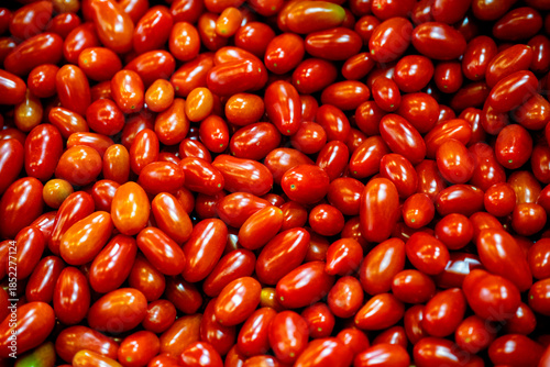 фотографія Selective focus of clean fresh small red tomatoes in a plactic bags for sale at a local market