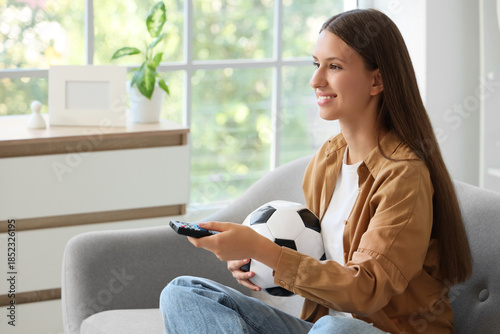 Young woman with TV remote ...