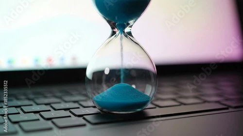 Time Running Out - Hourglass on Laptop Keyboard.
