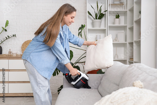 Young woman vacuum cleaning...