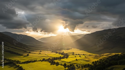 Mountain valley with sun rays through clouds