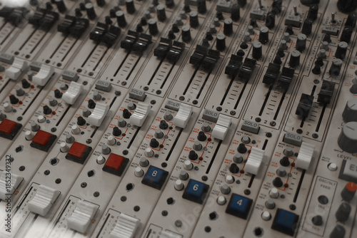 фотографія Vintage wooden audio mixing console with knobs, sliders, and buttons
