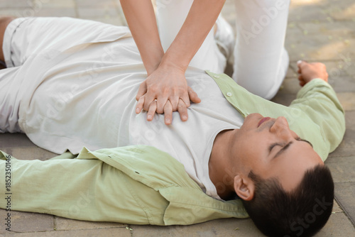 Young woman doing CPR on un...