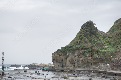 Scenic view of rhinoceros rock and lush green hills along the rugged coastline of Heping Island Park, Keelung, Taiwan.